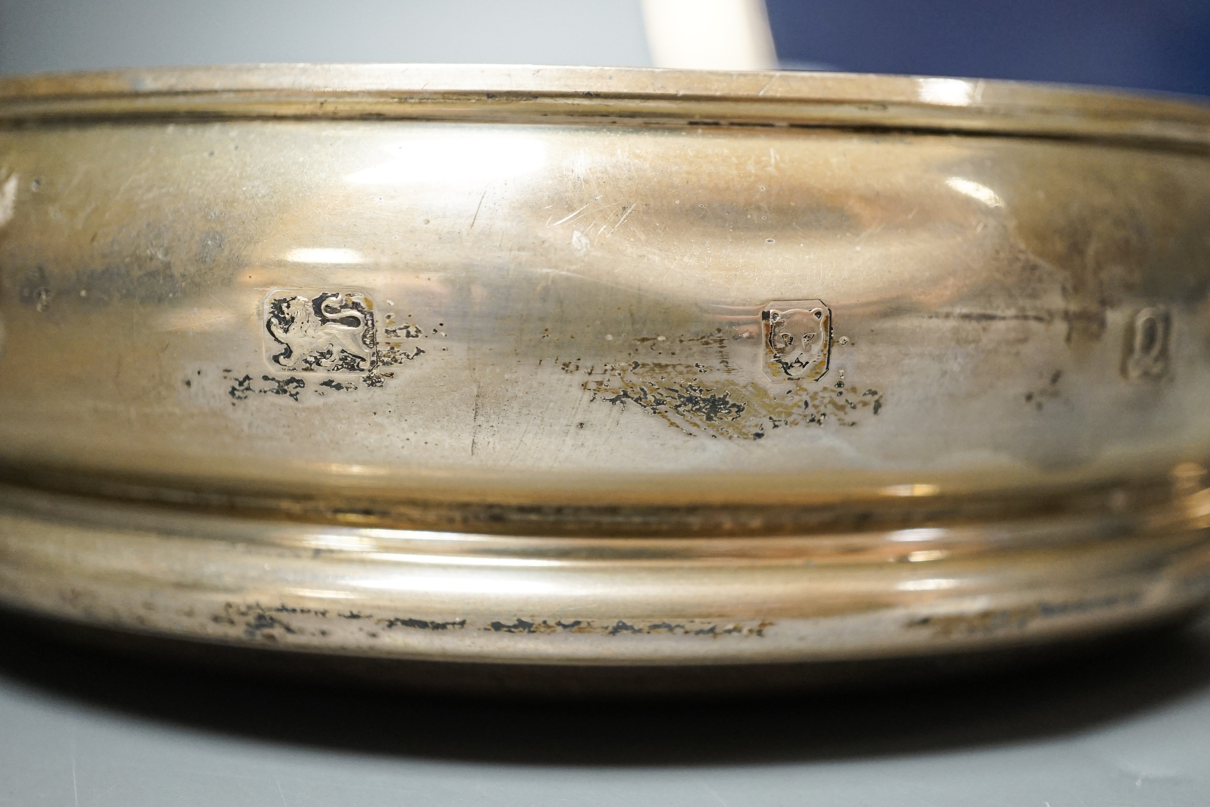 A pair of modern silver mounted wine coasters, W.E.V. London, 1990, (a.f.), 12.2cm and a 925 mounted oval photograph frame.